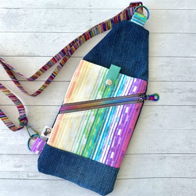 denim and multicolor stripe print mini sling bag with rainbow hardware