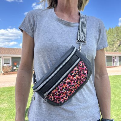 model wearing dark gray black pink red clamshell belt bag